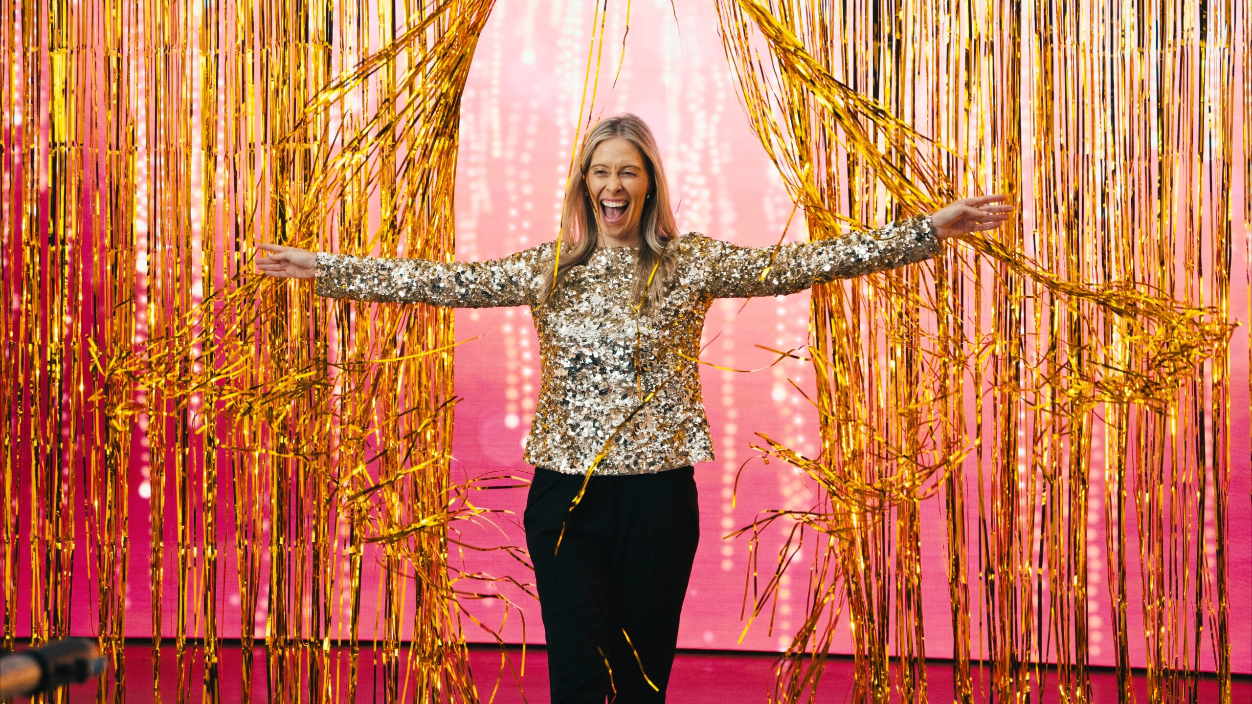 Taryn Scher emerges from golden confetti streamers